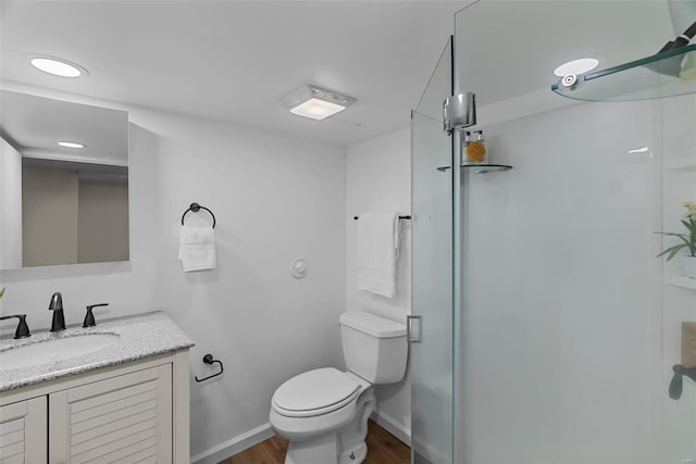 bathroom featuring hardwood / wood-style floors, vanity, toilet, and a shower with door