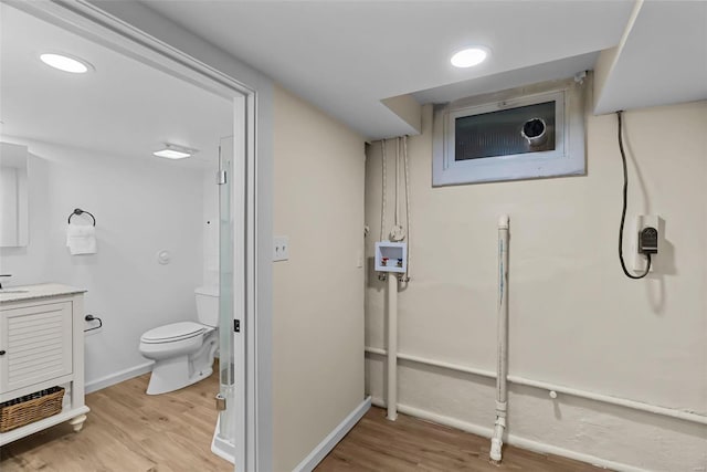 bathroom with hardwood / wood-style floors, vanity, and toilet