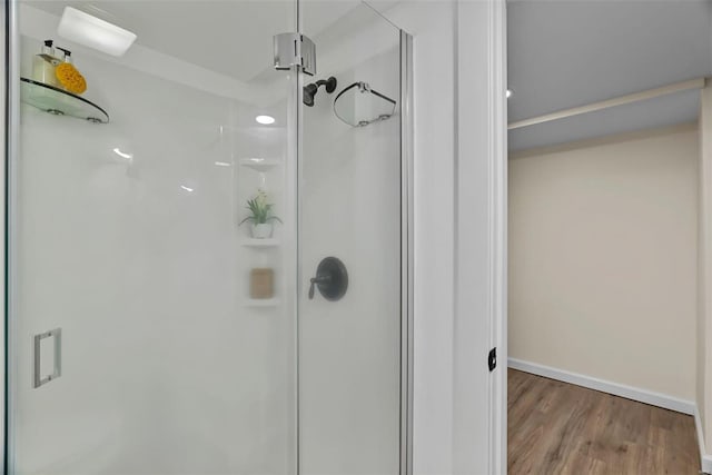 bathroom with hardwood / wood-style flooring and a shower with door