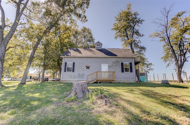 back of house featuring a deck and a lawn