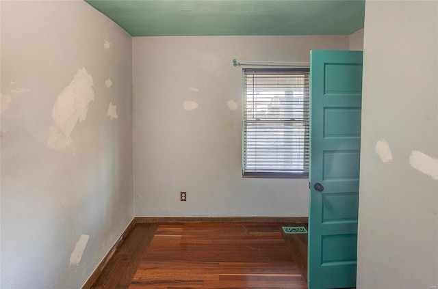 unfurnished room with dark wood-type flooring