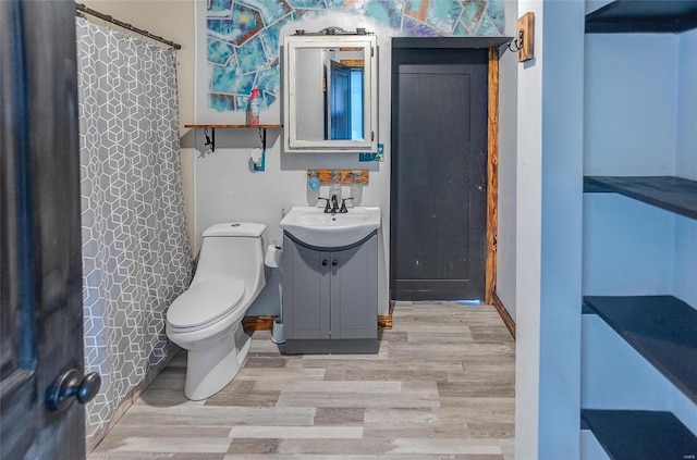 bathroom featuring wood-type flooring, vanity, toilet, and a shower with shower curtain