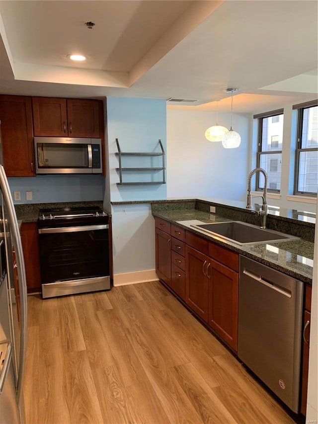 kitchen featuring light hardwood / wood-style floors, hanging light fixtures, stainless steel appliances, and sink