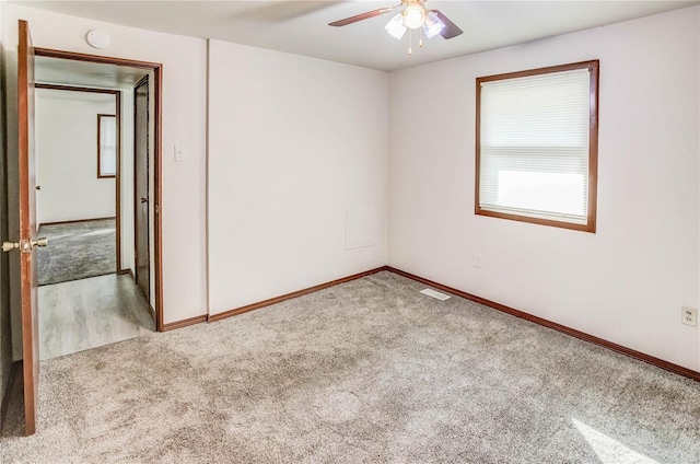 spare room featuring light carpet and ceiling fan