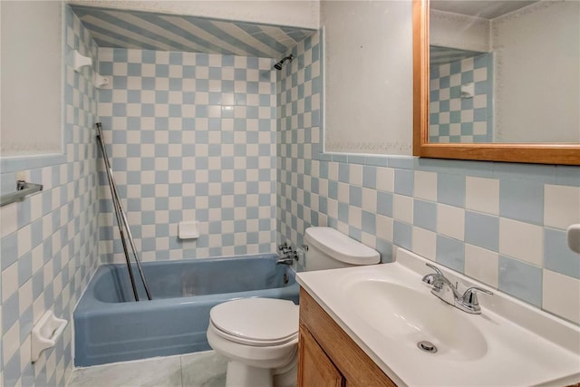 full bathroom with tile walls, vanity, toilet, and tiled shower / bath combo