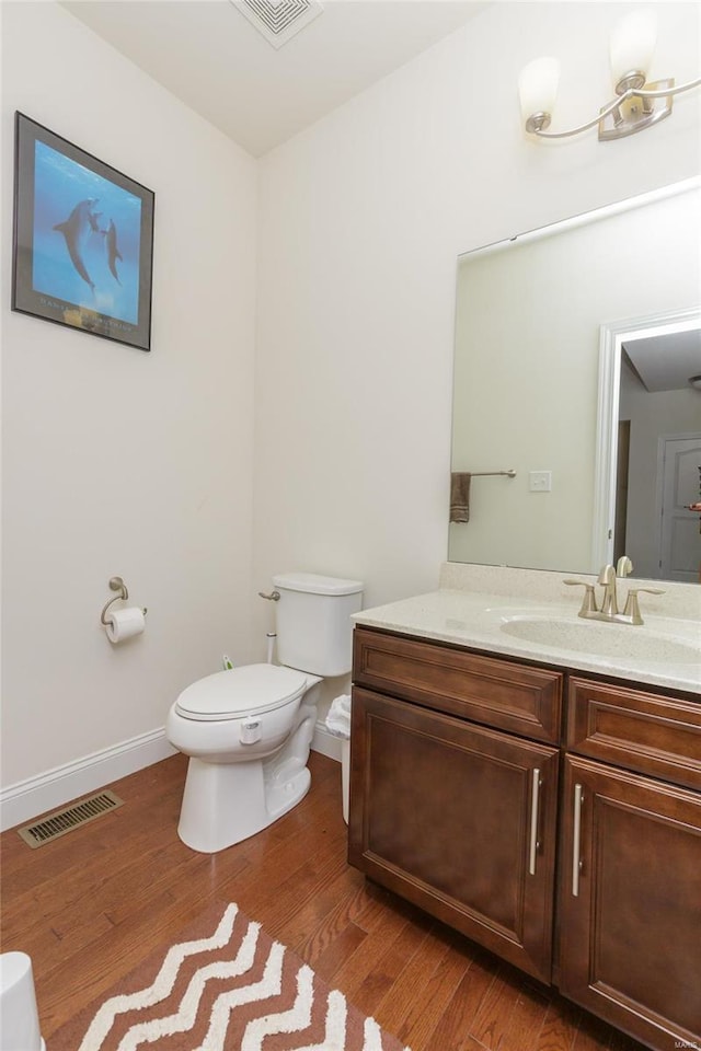 bathroom featuring hardwood / wood-style flooring, vanity, and toilet