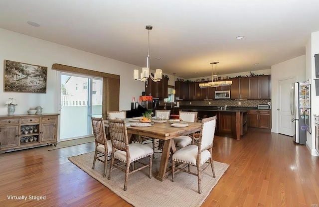 dining area featuring hardwood / wood-style flooring, a chandelier, and sink