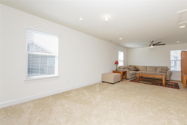 living room with plenty of natural light, light carpet, and ceiling fan