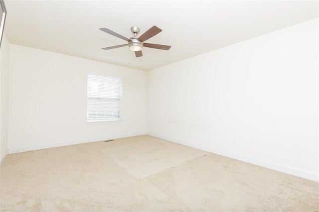 unfurnished room with light colored carpet and ceiling fan