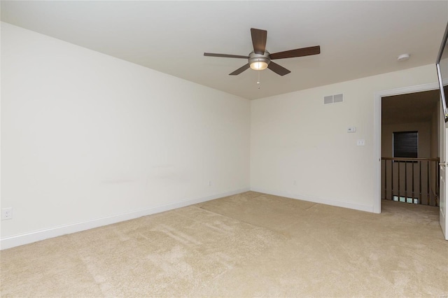 empty room featuring light colored carpet and ceiling fan