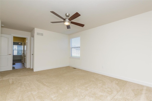 carpeted spare room featuring ceiling fan