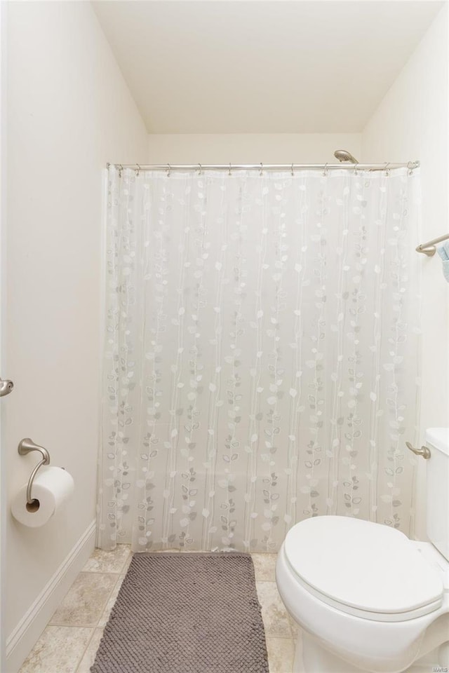 bathroom featuring vaulted ceiling, toilet, and tile patterned flooring