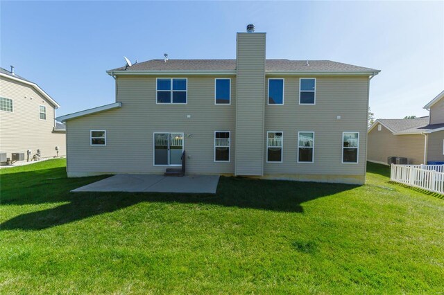 rear view of house featuring cooling unit, a patio area, and a lawn