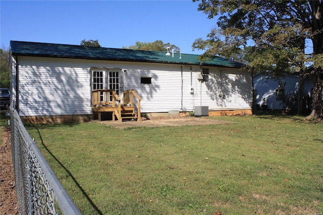 rear view of property with a yard and central AC