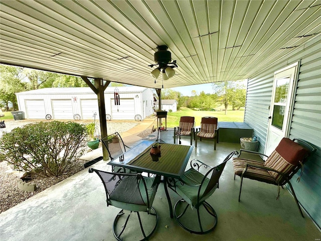 view of patio with a garage, an outbuilding, and ceiling fan