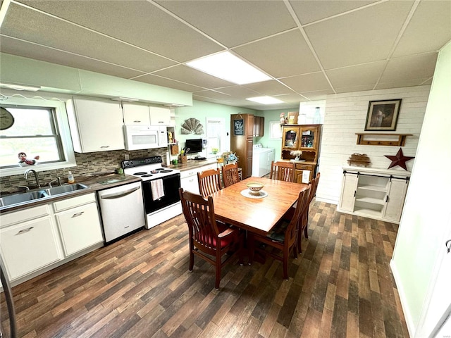 dining space with washer and clothes dryer, sink, a paneled ceiling, and dark hardwood / wood-style floors