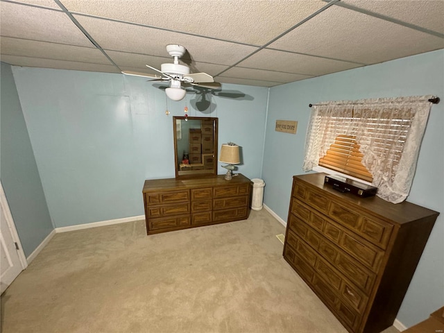 carpeted bedroom featuring ceiling fan and a paneled ceiling