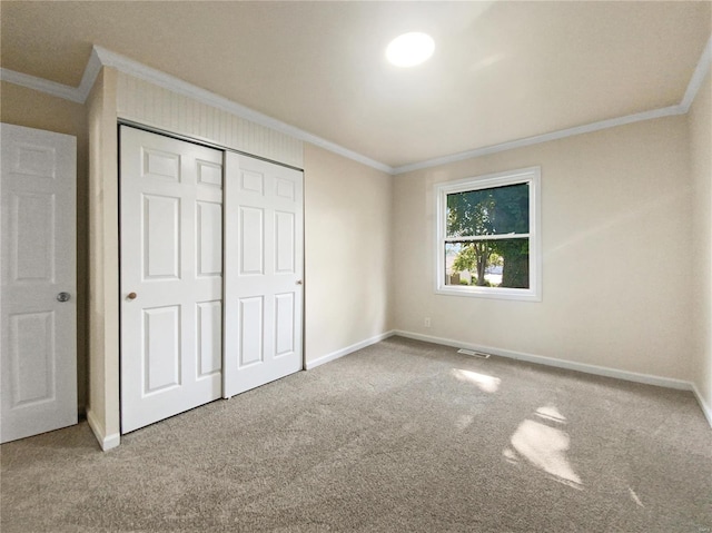 unfurnished bedroom featuring carpet floors, a closet, and ornamental molding