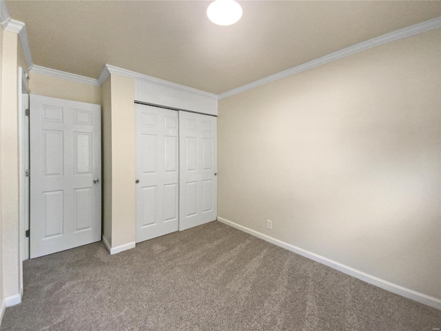 unfurnished bedroom featuring ornamental molding, carpet, and a closet