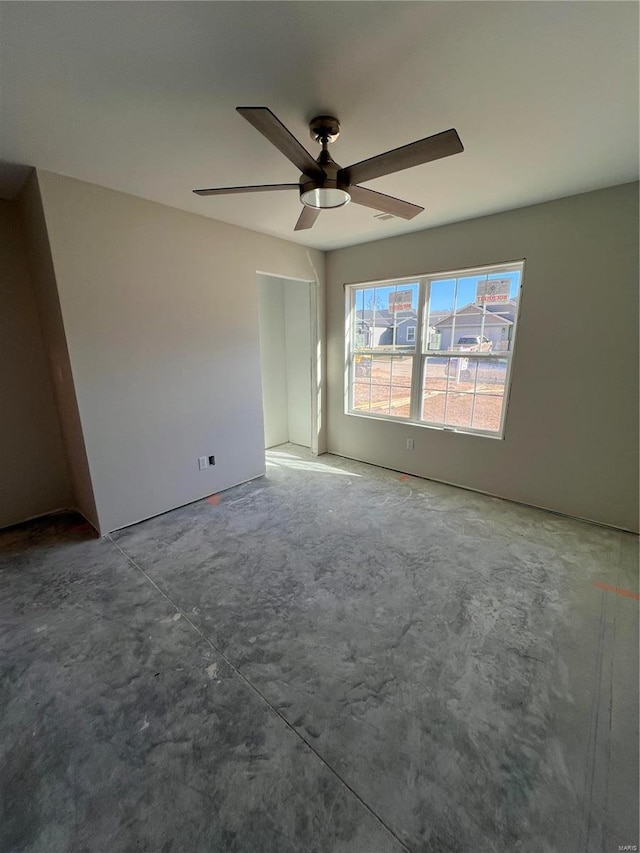 empty room with concrete floors and ceiling fan