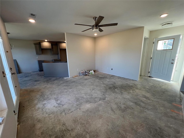 unfurnished living room featuring visible vents, unfinished concrete flooring, and ceiling fan