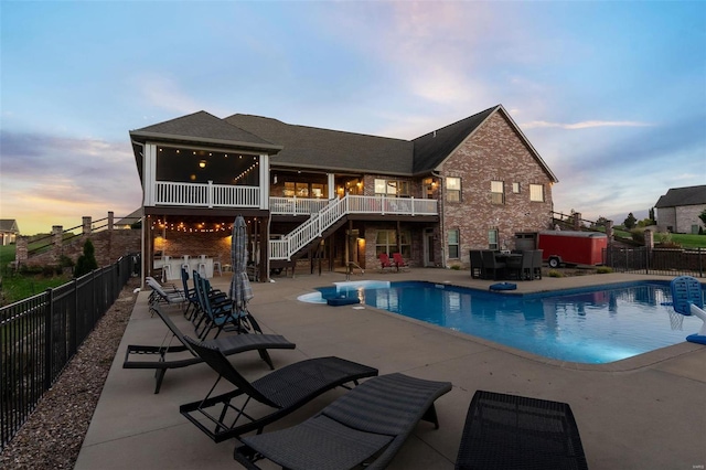 pool at dusk with a patio