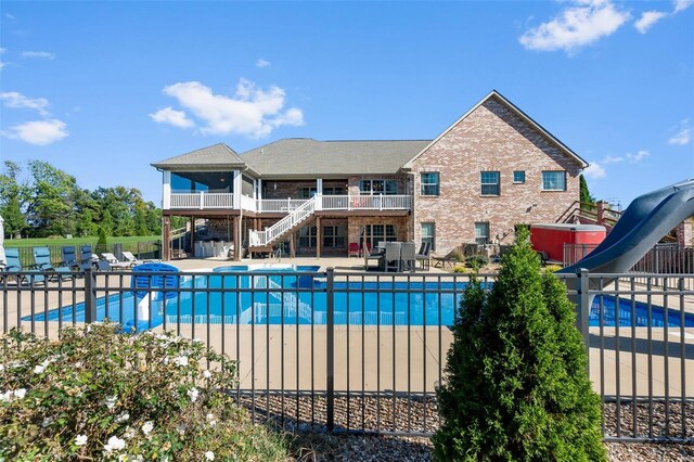 view of pool featuring a water slide and a patio