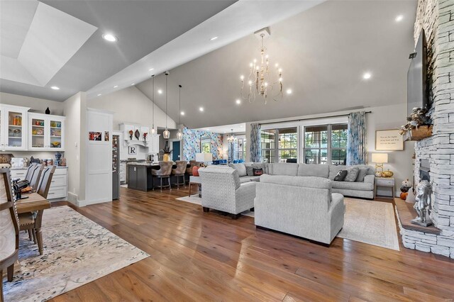 living room with a notable chandelier, high vaulted ceiling, and dark hardwood / wood-style flooring