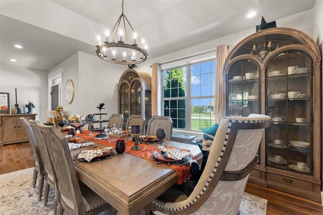 dining space featuring hardwood / wood-style flooring and an inviting chandelier