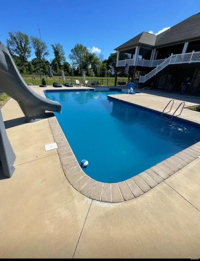 view of pool with a water slide and a patio