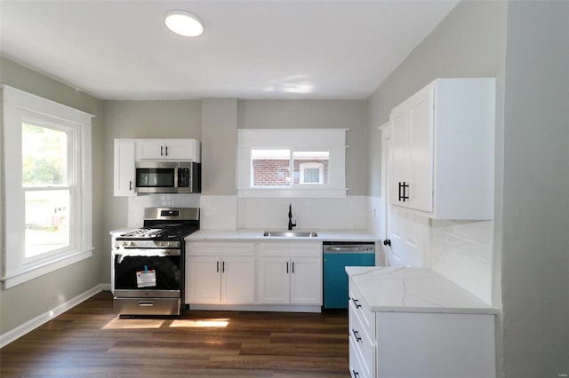 kitchen with stainless steel appliances, white cabinets, plenty of natural light, and sink