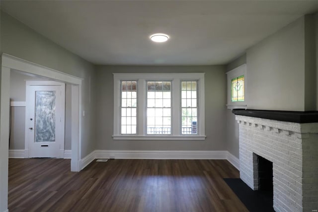 unfurnished living room featuring a fireplace and dark wood-type flooring