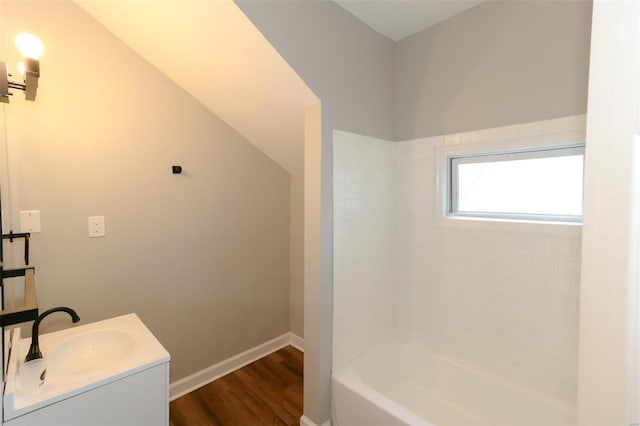 bathroom with tiled shower / bath, lofted ceiling, vanity, and hardwood / wood-style flooring