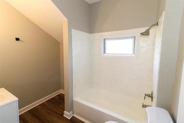 full bathroom with hardwood / wood-style floors, tiled shower / bath combo, vanity, and toilet