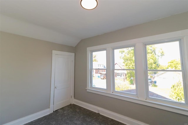 carpeted spare room featuring lofted ceiling