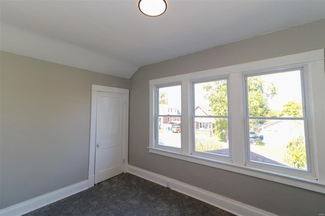 carpeted spare room with vaulted ceiling