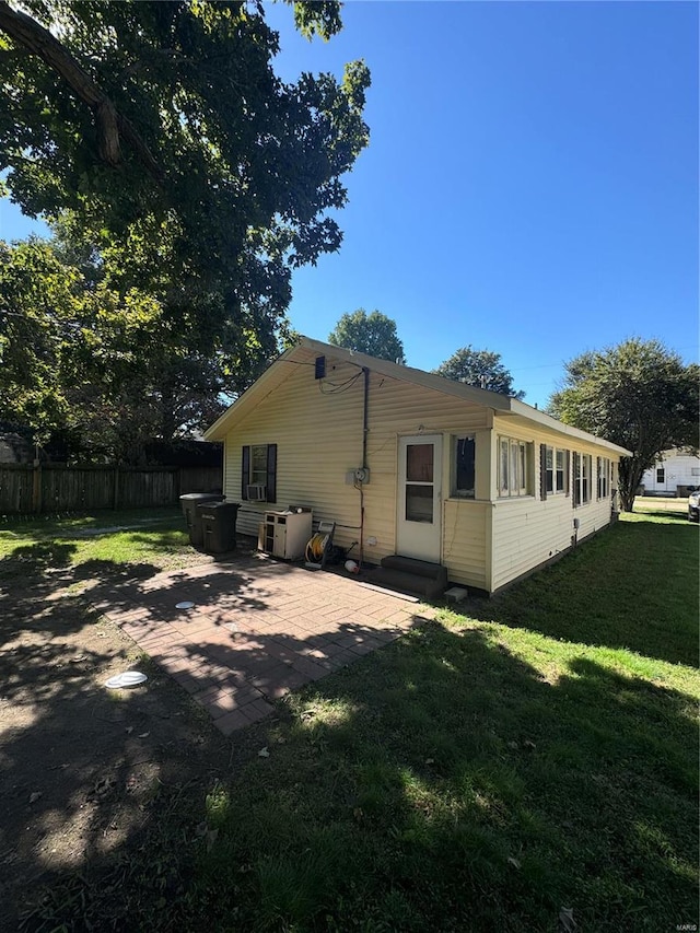 rear view of property featuring a lawn and a patio area