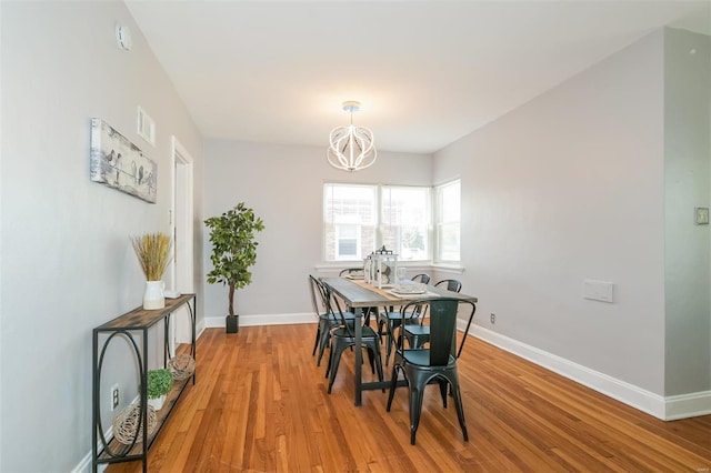 dining area with a chandelier and light hardwood / wood-style flooring