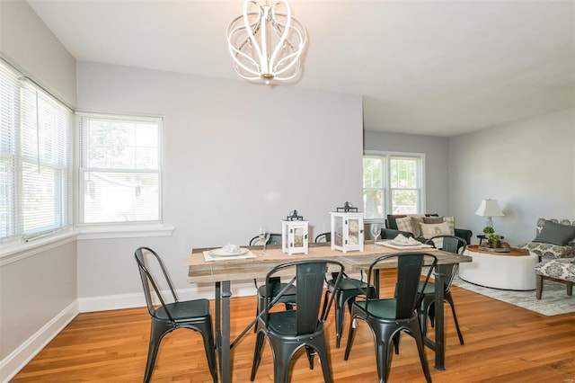 dining space featuring an inviting chandelier and light hardwood / wood-style flooring