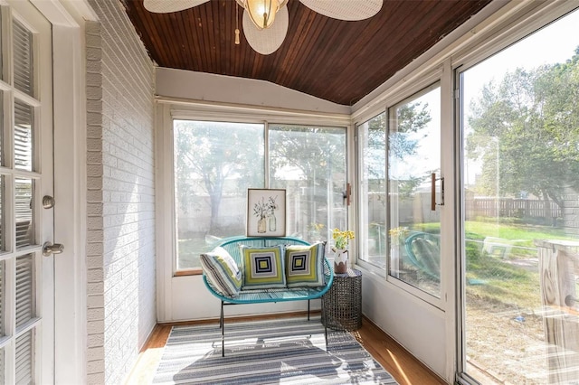 sunroom featuring a healthy amount of sunlight, ceiling fan, vaulted ceiling, and wooden ceiling