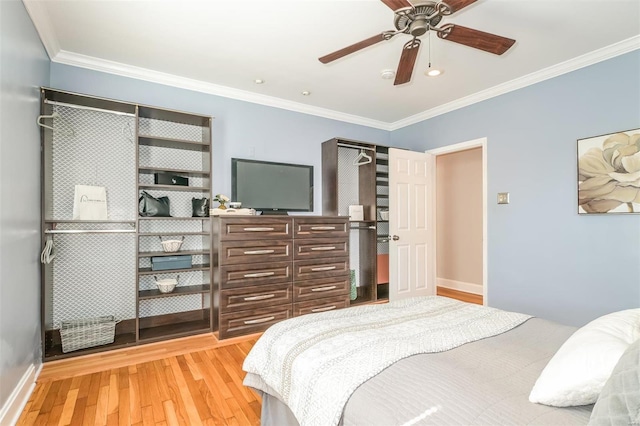 bedroom featuring a closet, light hardwood / wood-style flooring, ornamental molding, and ceiling fan