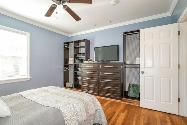 bedroom featuring wood-type flooring, crown molding, and ceiling fan