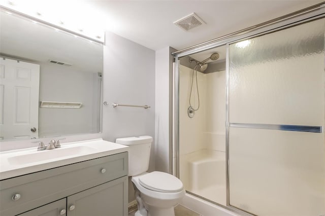 bathroom with toilet, vanity, and an enclosed shower