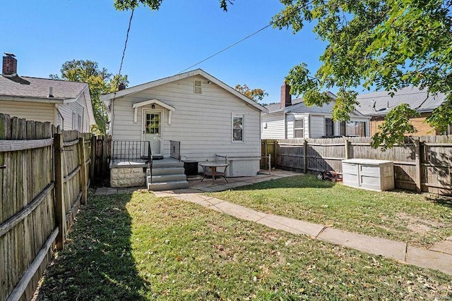 rear view of house featuring a yard and a patio