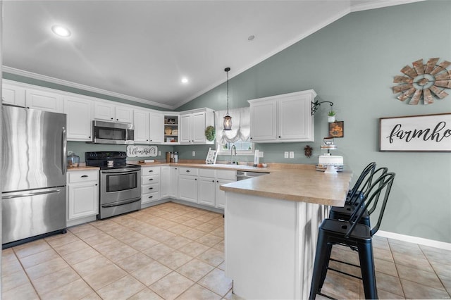 kitchen featuring kitchen peninsula, stainless steel appliances, ornamental molding, pendant lighting, and white cabinets