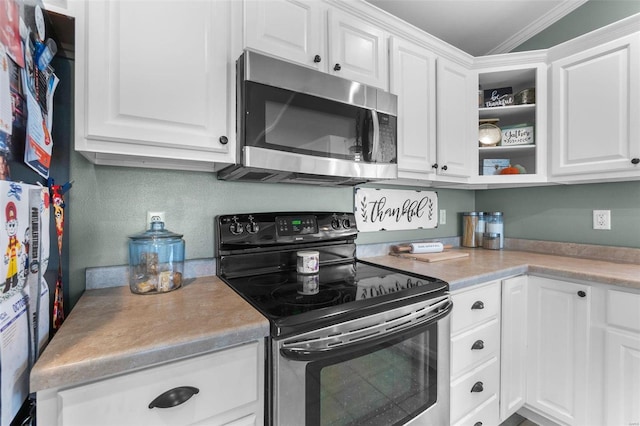 kitchen with black / electric stove, ornamental molding, and white cabinets