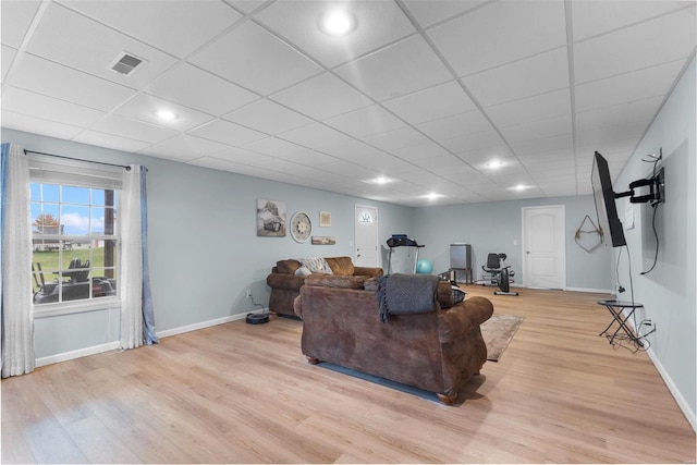 living room featuring a paneled ceiling and light hardwood / wood-style floors