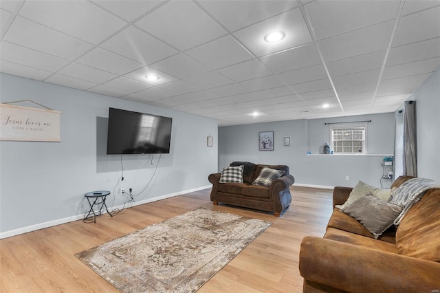 living room with a paneled ceiling and light wood-type flooring