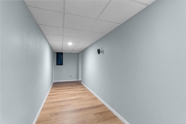 interior space with a drop ceiling and hardwood / wood-style flooring