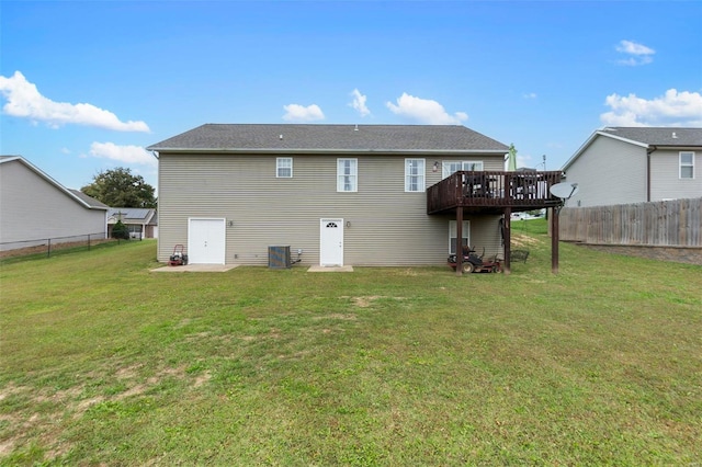 rear view of property featuring cooling unit, a deck, and a lawn